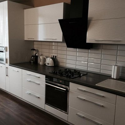 Черно-белая глянцевая кухня со встроенной техникой в современном стиле