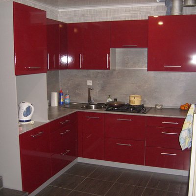 Угловая кухня с глянцевыми фасадами бордового цвета